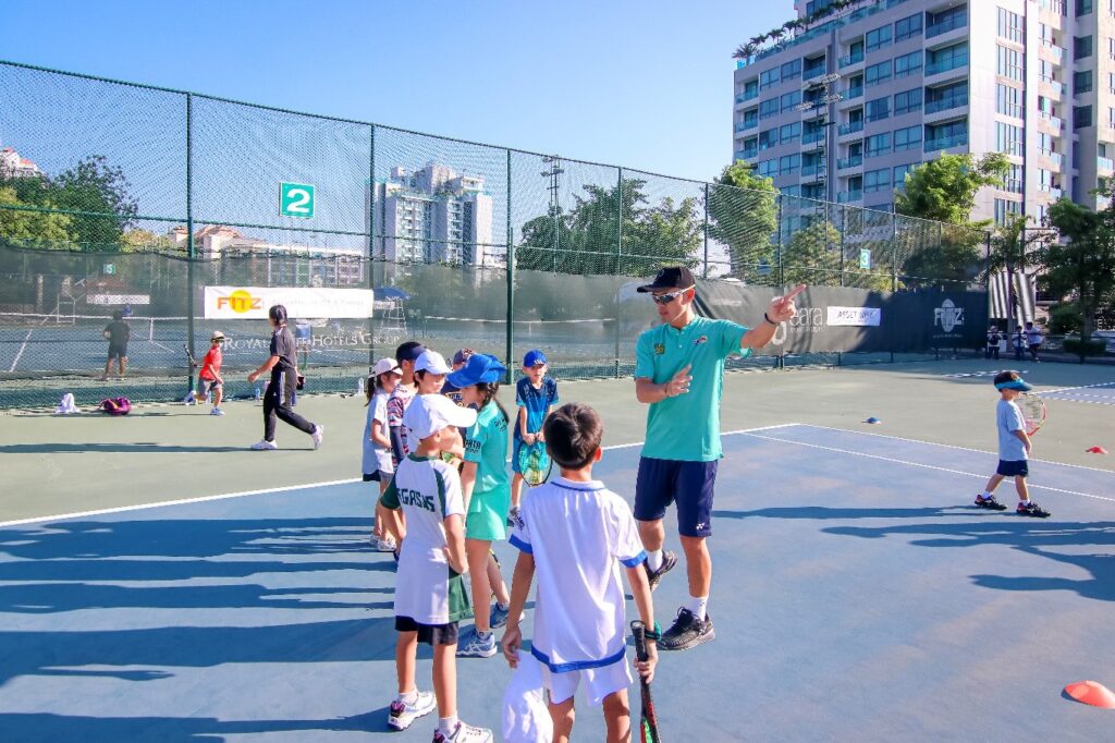 danai udomchoke teaching young players at fitz club pattaya tennis courts