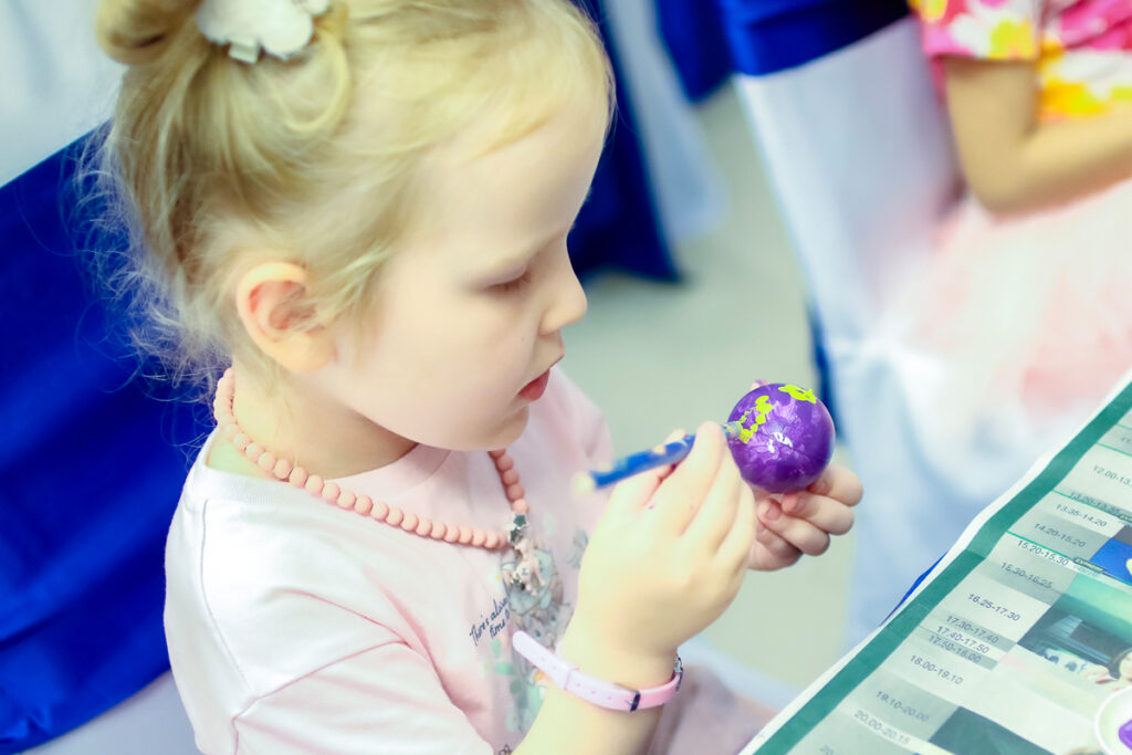 Young guest painting an egg for 2024 Easter holiday